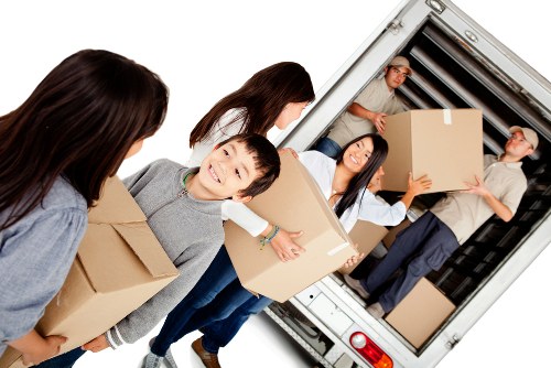 Moving team loading items safely beside a van