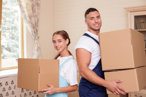 Two movers lifting furniture with correct manual handling technique